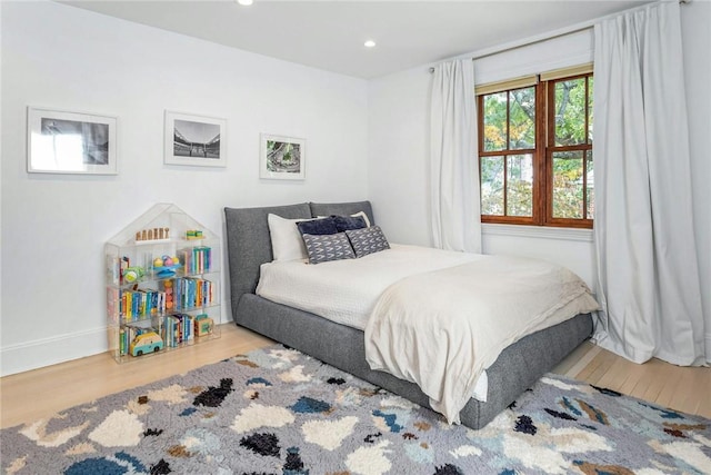 bedroom with baseboards, wood finished floors, and recessed lighting