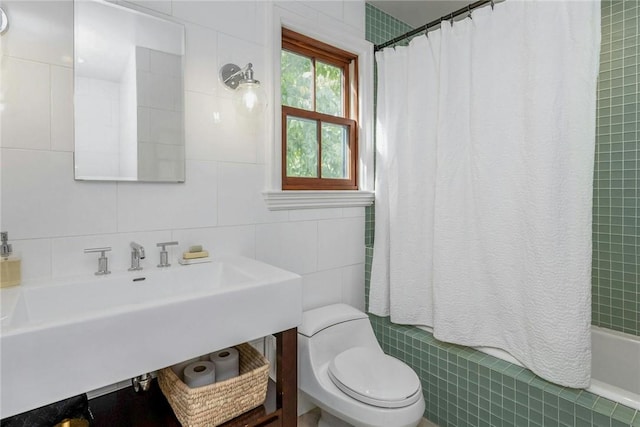 bathroom with toilet, shower / tub combo, a sink, tile walls, and decorative backsplash