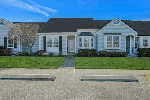 view of front of house featuring roof with shingles and a front lawn