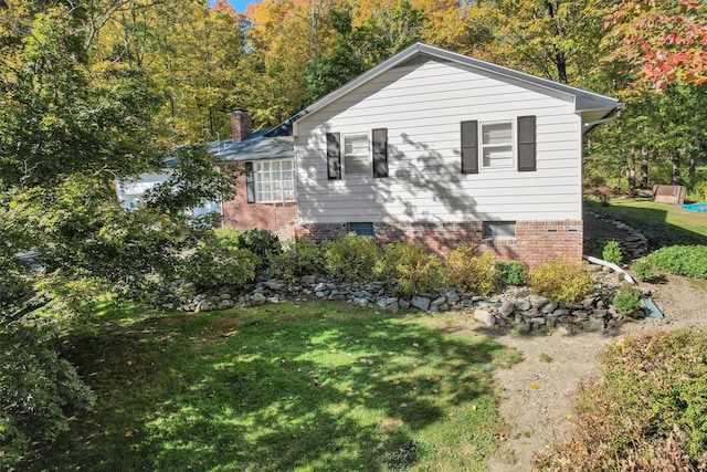 view of property exterior with a yard and a chimney