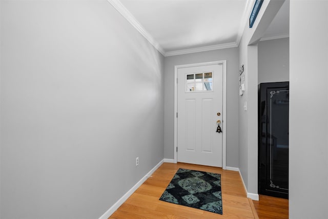 entryway with light wood-style floors, baseboards, and ornamental molding