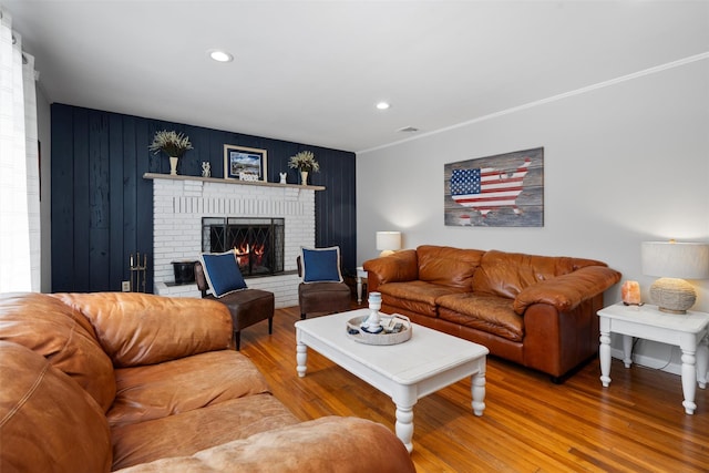 living room with recessed lighting, visible vents, wood finished floors, and a fireplace