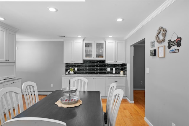 dining area with recessed lighting, light wood-type flooring, baseboards, and crown molding