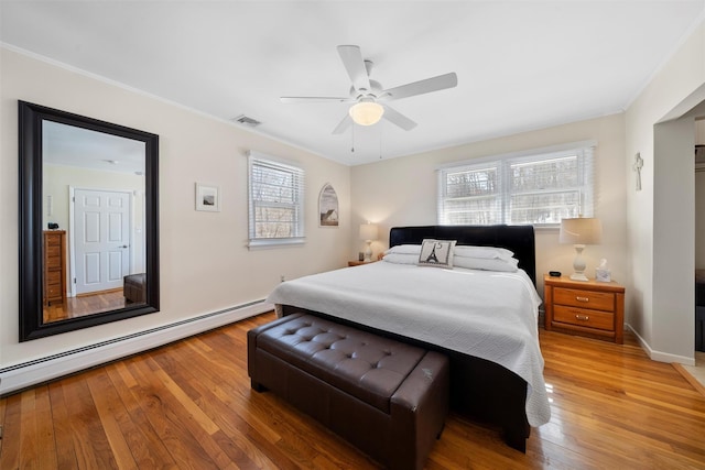 bedroom with hardwood / wood-style floors, visible vents, a baseboard heating unit, and ornamental molding