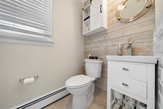 half bath featuring baseboard heating, wood walls, toilet, and vanity