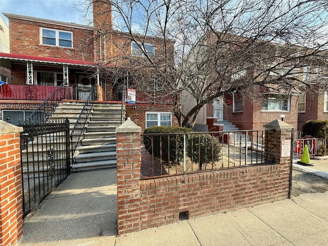 view of front of house with a fenced front yard and brick siding