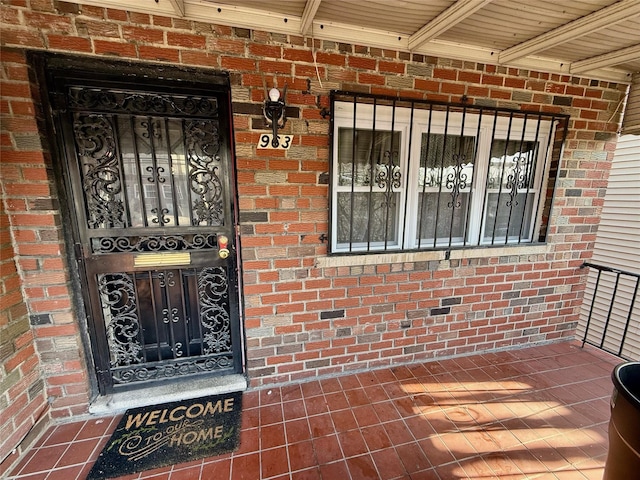 doorway to property with brick siding