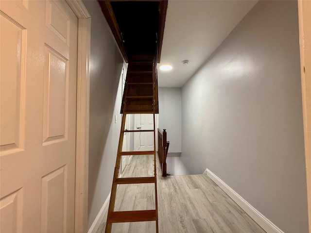 stairway featuring baseboards and wood finished floors