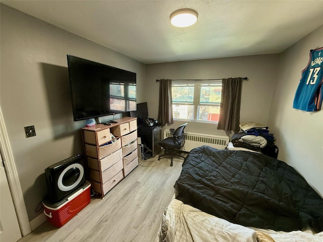 bedroom featuring light wood-style floors and radiator