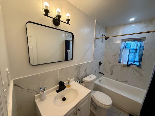 bathroom with tile walls, shower / bathtub combination, toilet, wainscoting, and vanity