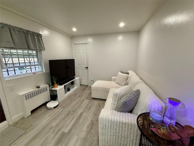 living area featuring light wood-type flooring, radiator, and recessed lighting