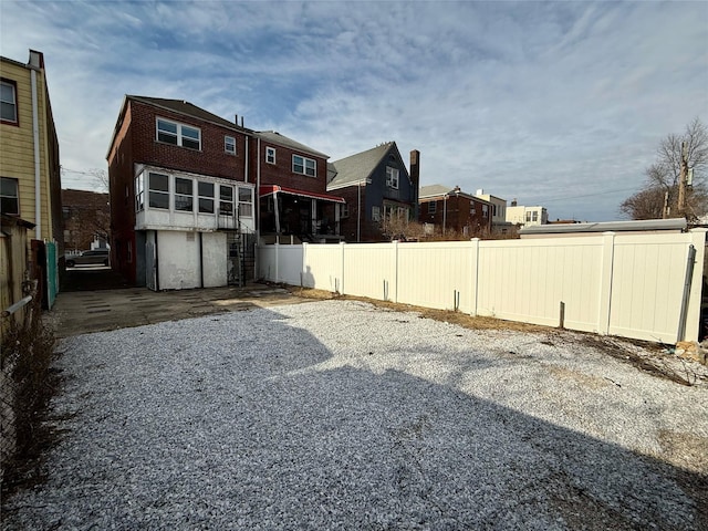 rear view of property featuring fence