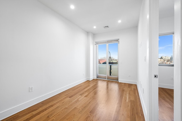 unfurnished room with light wood finished floors, recessed lighting, visible vents, and baseboards