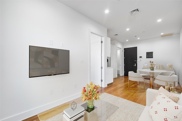 living area with baseboards, wood finished floors, visible vents, and recessed lighting