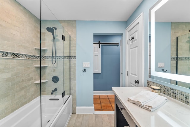 bathroom with vanity, shower / bathing tub combination, baseboards, and wood finished floors