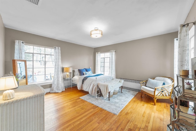 bedroom with radiator and wood finished floors