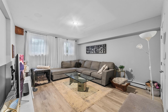 living area featuring a baseboard heating unit and wood finished floors