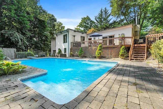 view of swimming pool featuring a fenced in pool, fence, a wooden deck, stairs, and a patio area