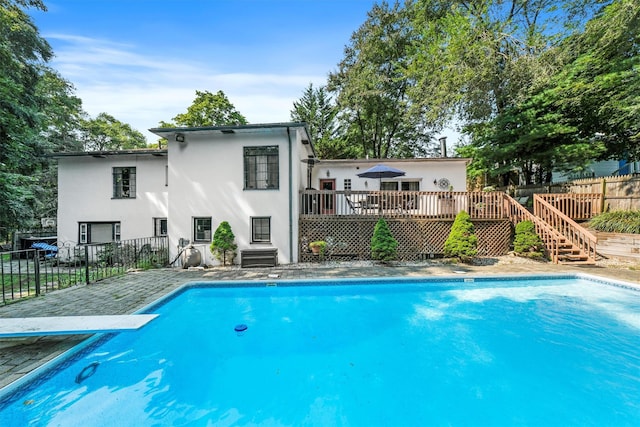 view of swimming pool with stairs, fence, a fenced in pool, and a wooden deck