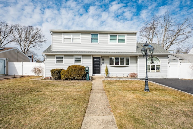 traditional home featuring fence and a front lawn