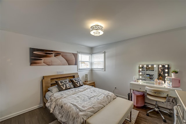 bedroom with ornamental molding, dark wood finished floors, and baseboards