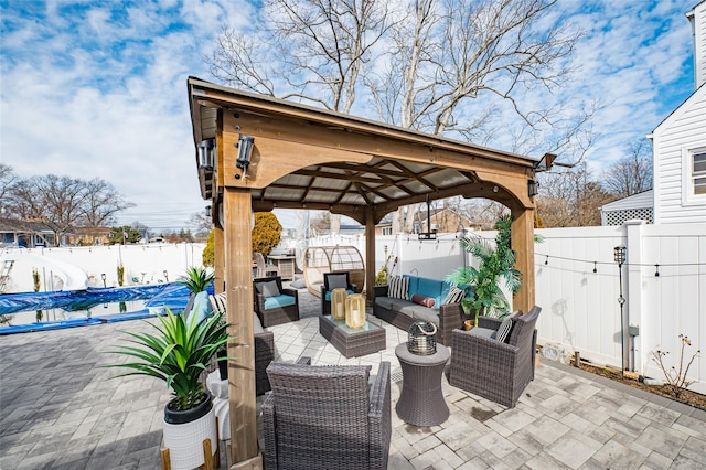 view of patio with a fenced backyard, an outdoor living space, and a gazebo