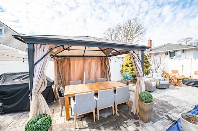 view of patio / terrace with outdoor dining area, fence, and a gazebo