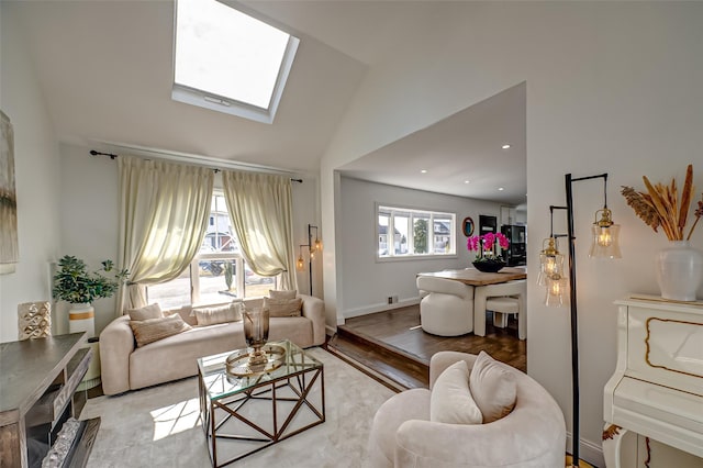 living area featuring vaulted ceiling with skylight, light wood-style flooring, baseboards, and recessed lighting