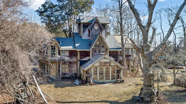 rear view of property with a sunroom and a shingled roof