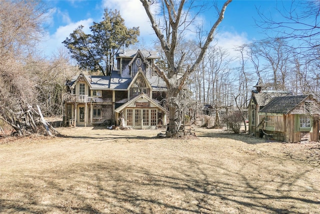 back of house featuring french doors and an outdoor structure