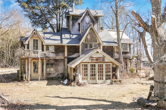 back of house with roof with shingles