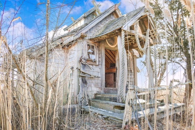 view of side of property featuring a shingled roof