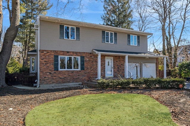 traditional-style home with a garage, a front lawn, and brick siding