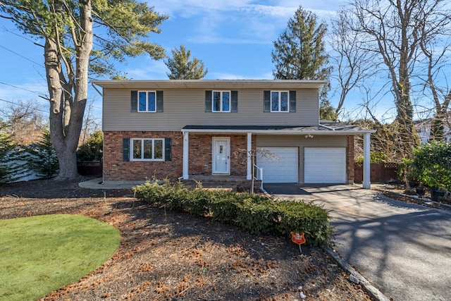 traditional-style house with brick siding, driveway, an attached garage, and fence