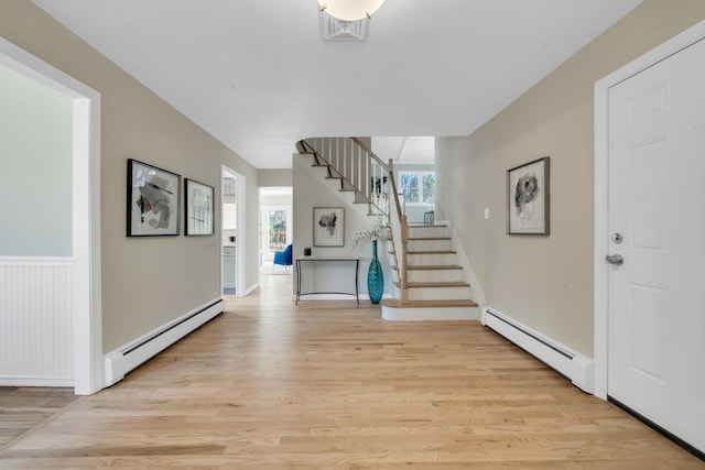 foyer entrance with light wood-style flooring, visible vents, stairway, and baseboard heating