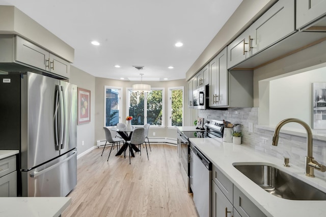 kitchen featuring a sink, stainless steel appliances, light countertops, and gray cabinetry