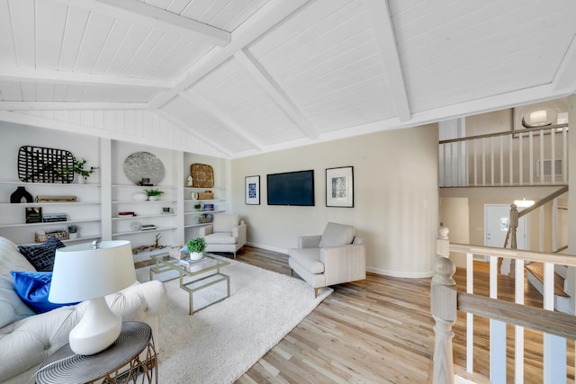 living room featuring light wood finished floors, visible vents, baseboards, lofted ceiling with beams, and built in shelves