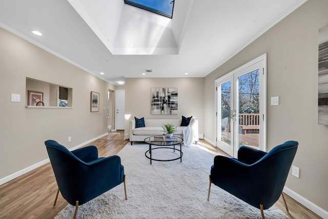 living area with light wood-style floors, a skylight, baseboards, and recessed lighting