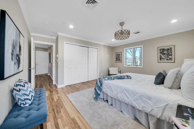 bedroom with ornamental molding, light wood-type flooring, visible vents, and baseboards