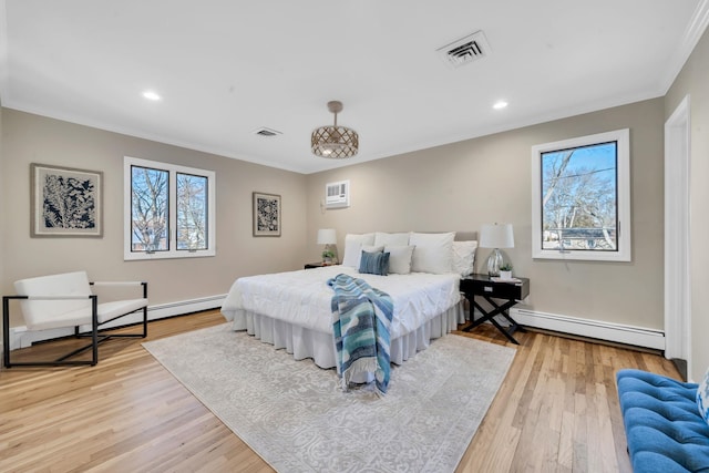 bedroom featuring light wood-type flooring, a baseboard radiator, multiple windows, and visible vents