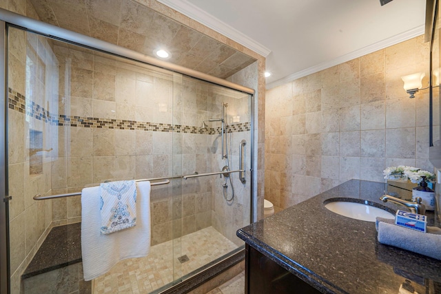 bathroom featuring crown molding, tile walls, toilet, a shower stall, and vanity