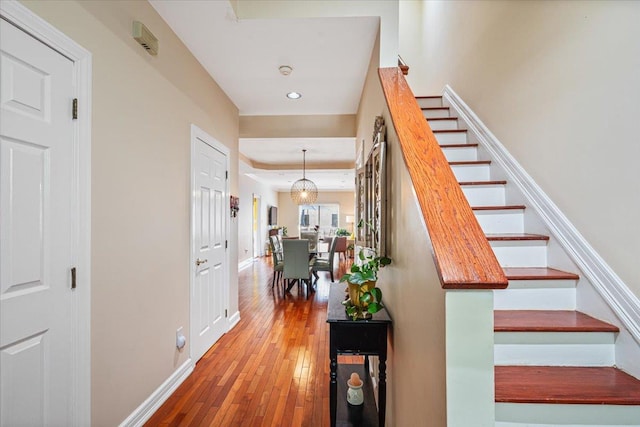 staircase with recessed lighting, wood-type flooring, and baseboards