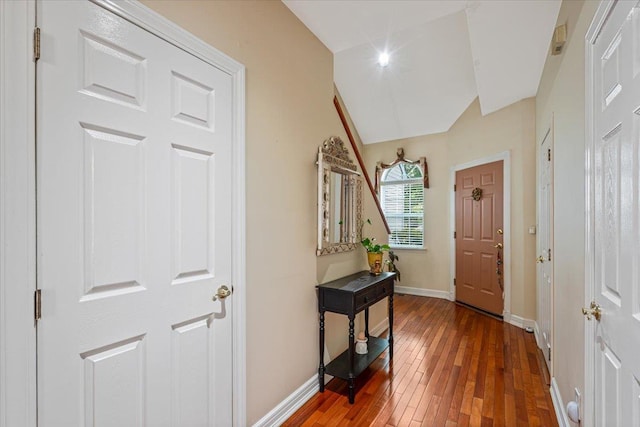 entryway with stairway, baseboards, vaulted ceiling, and hardwood / wood-style floors