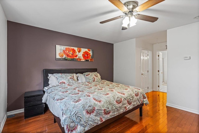 bedroom with a ceiling fan, baseboards, and wood finished floors