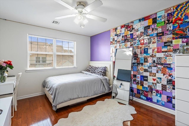 bedroom with a ceiling fan, baseboards, visible vents, and wood finished floors