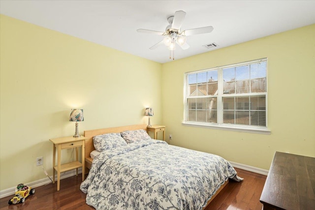 bedroom with baseboards, visible vents, and dark wood finished floors