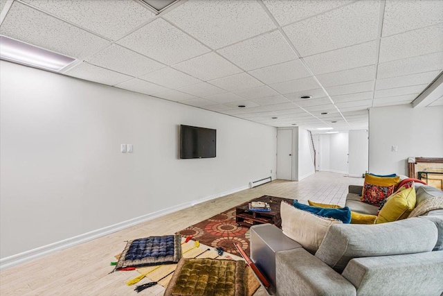 living room with baseboards, a drop ceiling, baseboard heating, and wood finished floors