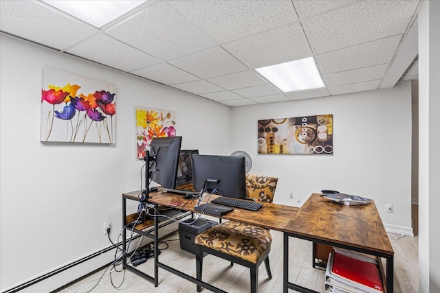 home office with a paneled ceiling, baseboards, and wood finished floors