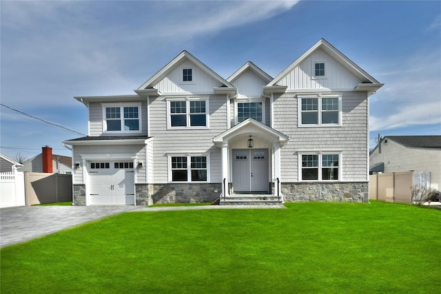 view of front facade featuring decorative driveway, fence, a garage, stone siding, and a front lawn