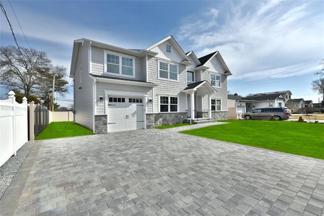 view of front of property featuring a garage, fence, stone siding, decorative driveway, and a front lawn